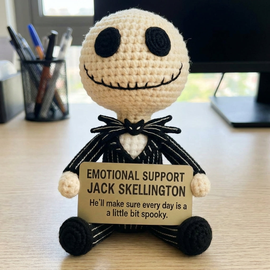 Crocheted figure of Jack Skellington holding a sign on a desk