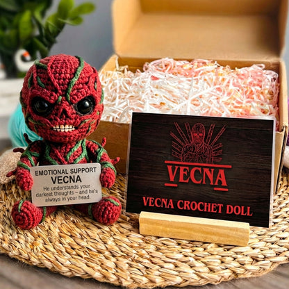 Vecna crochet doll with a wooden sign and tag on a woven mat